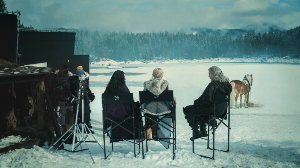 Imagen del set de la serie de Netflix 'The Witcher' en un paraje nevado, que muestra a los personajes de Yennefer, Ciri y Geralt sentados de espalda