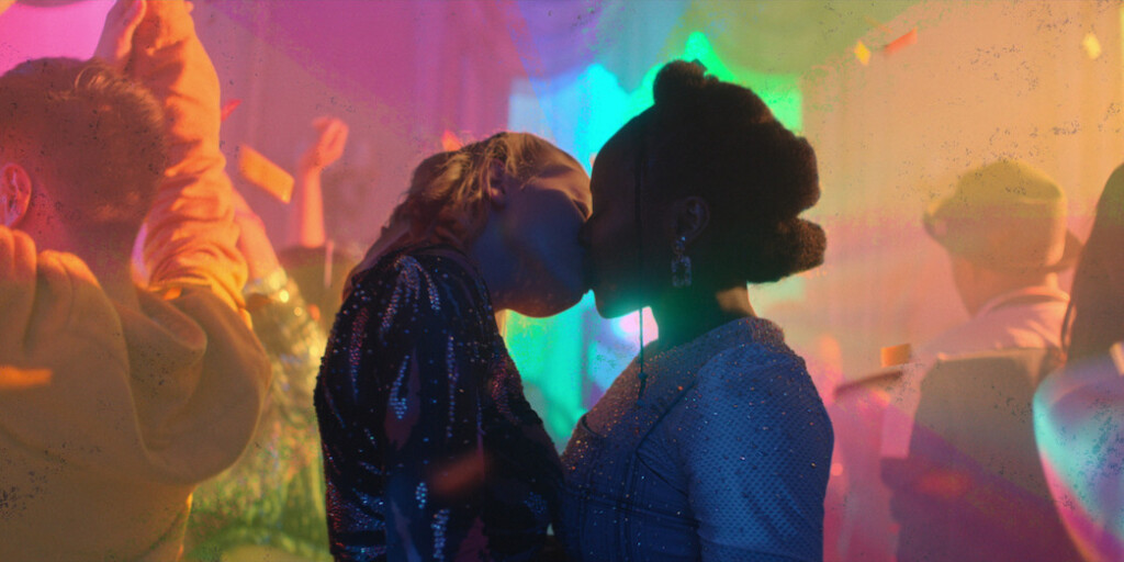 Tara y Darcy besándose bajo una luz de colores en 'Heartstopper'
